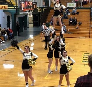 Cheerleaders prepare stunts for basketball games