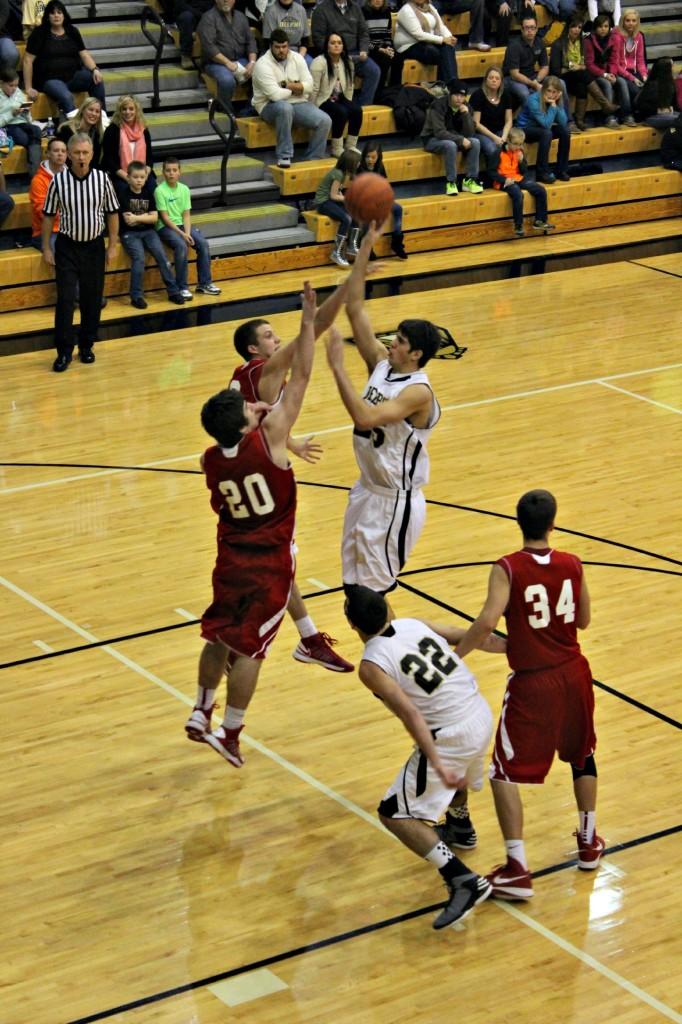 Senior Cole Murray soars over two opponents for 2 of his 25 points.  Delphi defeated the Hornets 50-44.