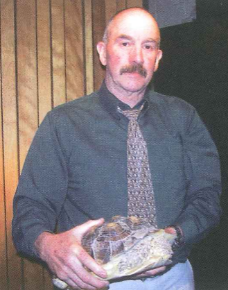 Mr. Brannan poses with George the tortoise, getting ready to wash him in the janitors closet behind the Little Theater. (circa 2006)