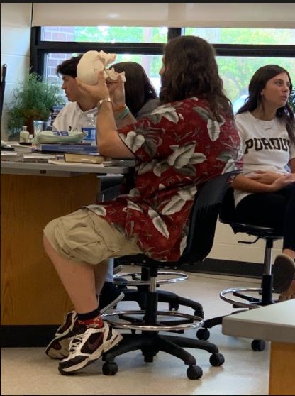 Senior Connor Reilly looking at a human skull in Anatomy.
