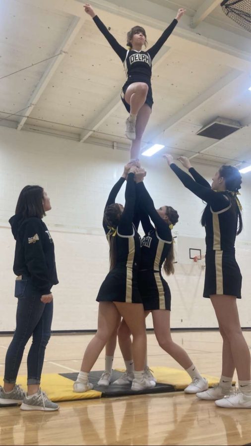 Cheer team practices a stunt before the basketball game. 